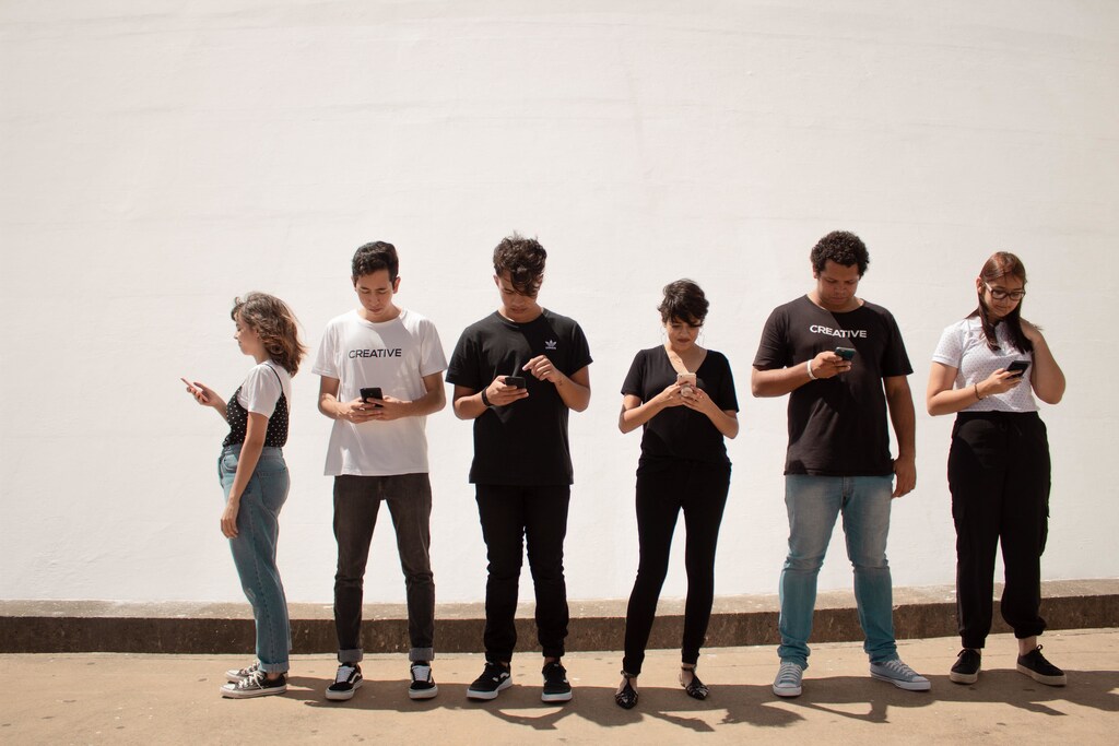 A group of young people using their mobile phones.