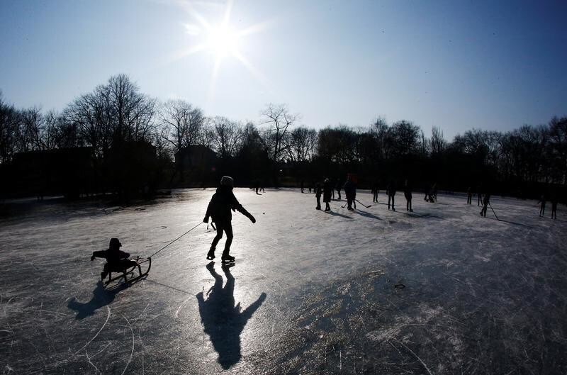 People walk and skate on the frozen lake Obersee in Berlin, Germany, March 4, 2018. REUTERS/Hannibal Hanschke - RC1199686E90