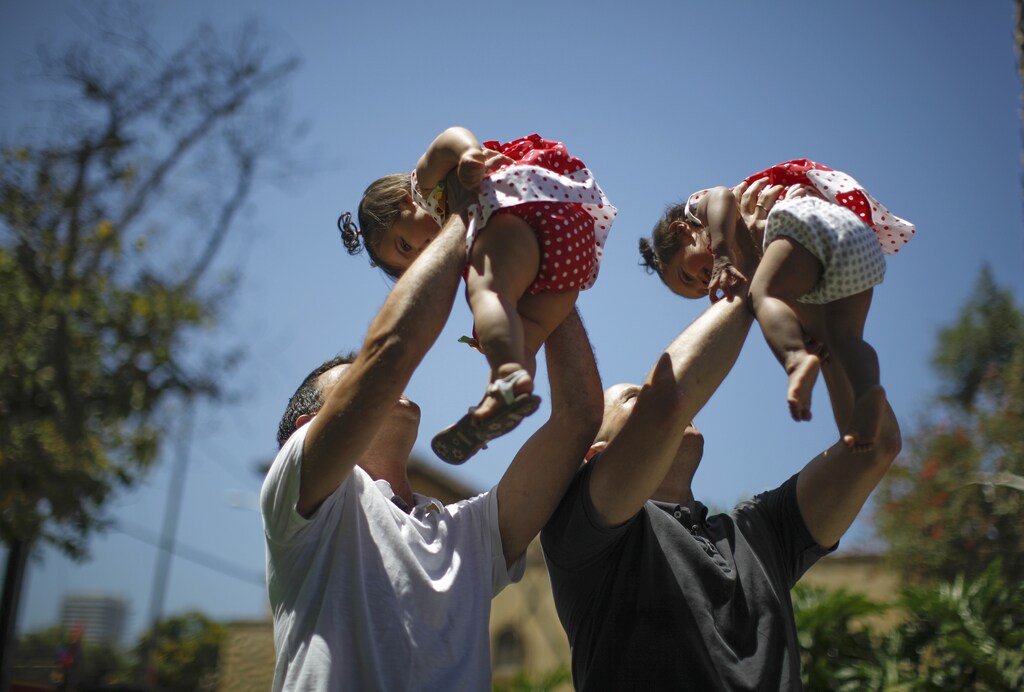 Jason Howe, 48, and Adrian Perez (L), 48, who were married in Spain, and again in California, hold their one-year-old twin daughters Clara (R) and Olivia at a playground in West Hollywood, California after the United States Supreme court ruled on California's Proposition 8 and the federal Defense of Marriage Act, June 26, 2013. The U.S. Supreme Court delivered a landmark victory for gay rights on Wednesday by forcing the federal government to recognize same-sex marriages in states where it is legal and paving the way for it in California, the most populous state. REUTERS/Lucy Nicholson (UNITED STATES - Tags: SOCIETY POLITICS TPX IMAGES OF THE DAY) - GM1E96R0IE001