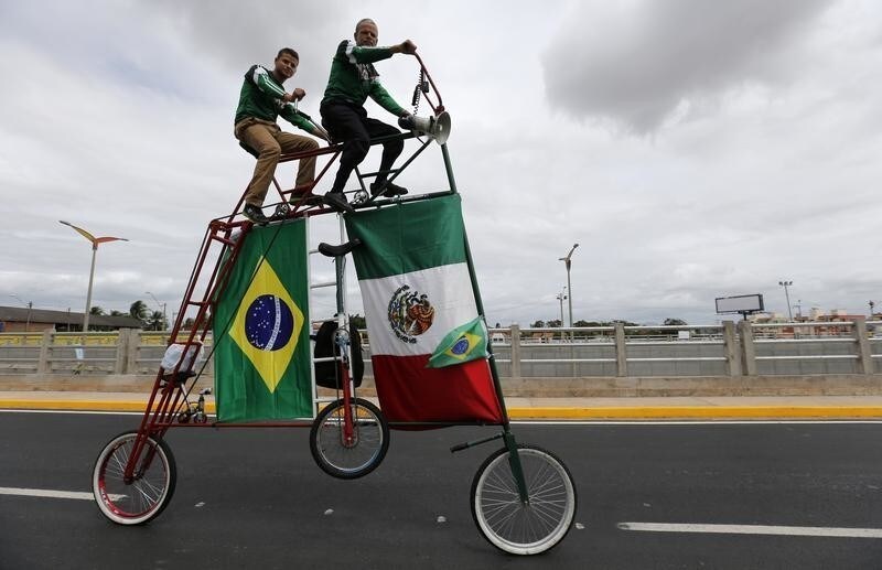 Fans of Mexico ride a big bike as they arrive at the Castelao stadium before Mexico's 2014 World Cup soccer match against Brazil in Fortaleza, Brazil June 17, 2014. REUTERS/Sergio Moraes (BRAZIL - Tags: SPORT SOCCER WORLD CUP) - TB3EA6H1C036T