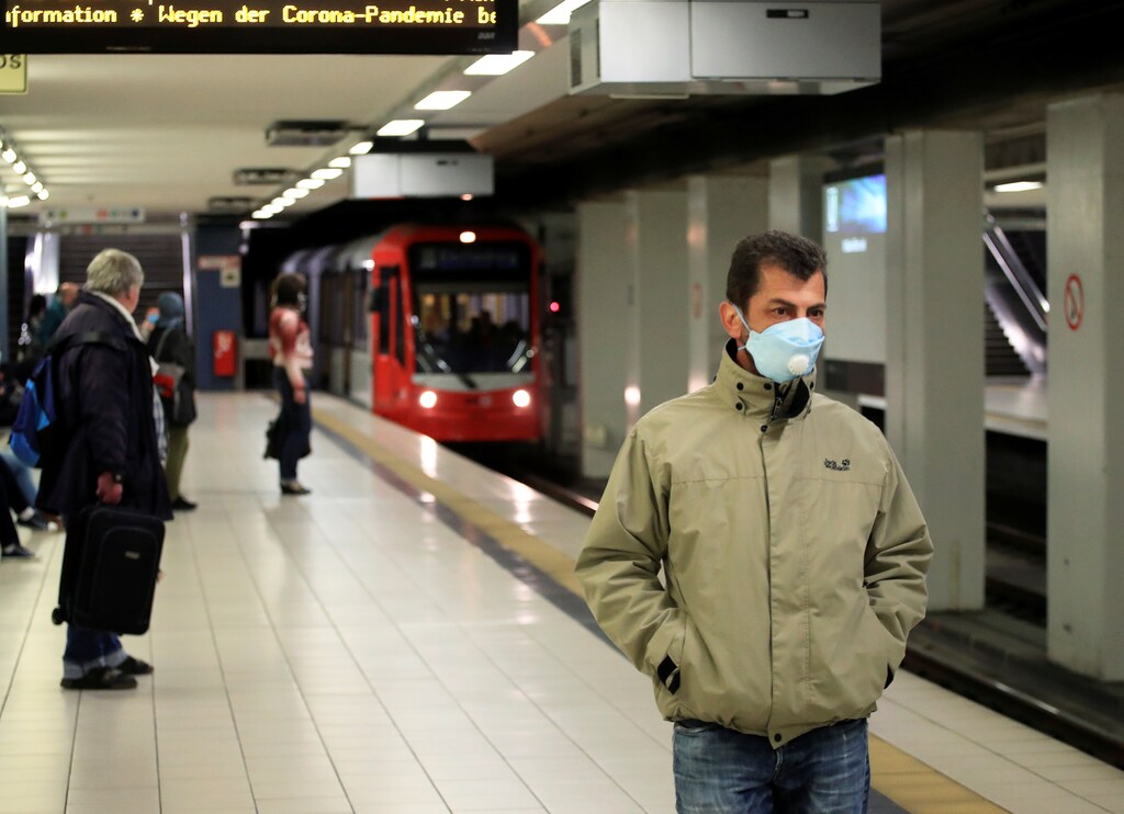A commuter wearing a face mask stands at the Cologne main station after the federal state of North Rhine-Westphalia decided to make wearing protective masks obligatory in buses, trains and shops to fight the spread of the coronavirus disease (COVID-19), in Cologne, Germany, April 27, 2020. REUTERS/Wolfgang Rattay - RC2UCG9Z09Z2