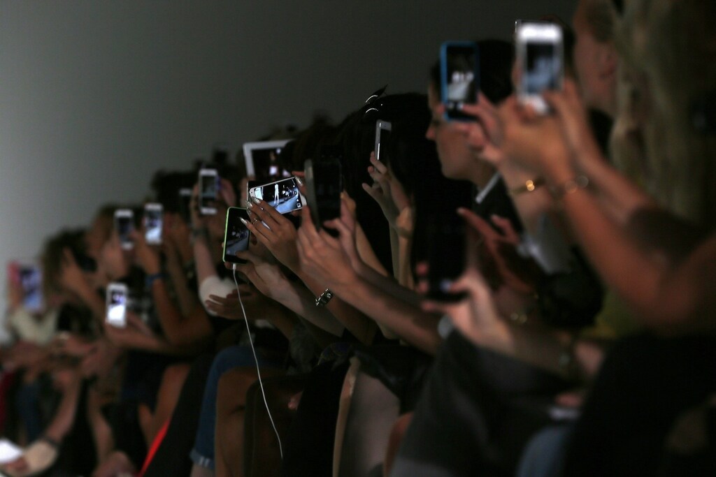 Guests use their mobile devices during the David Koma Spring/Summer 2015 collection presentation at London Fashion Week September 14, 2014. REUTERS/Stefan Wermuth (BRITAIN - Tags: FASHION) - RTR466NP