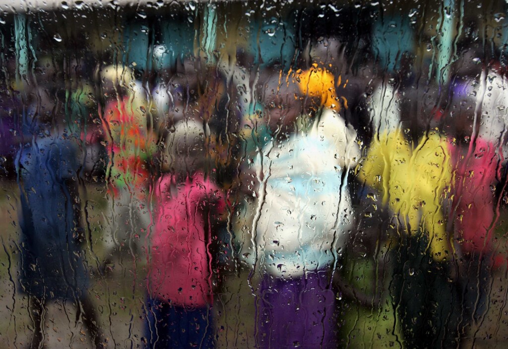 Internally displaced people are seen behind a window standing in the rain to welcome Tony Hall, the US ambassador to the UN Food and Agriculture Organisation (FAO) at Awoo camp in northern Uganda March 22, 2005. Uganda has been singled out as the most underreported humanitarian crisis, say Doctors Without Borders about the country where a bloody 19-year civil conflict rages on in the north and more than a million and half people have been displaced by rebel attacks and thousands of children live under constant threat of being kidnapped. NO RIGHTS CLEARANCES OR PERMISSIONS ARE REQUIRED FOR THIS IMAGE. REUTERS/Radu Sigheti RSS/acm - RP6DRNARGSAB