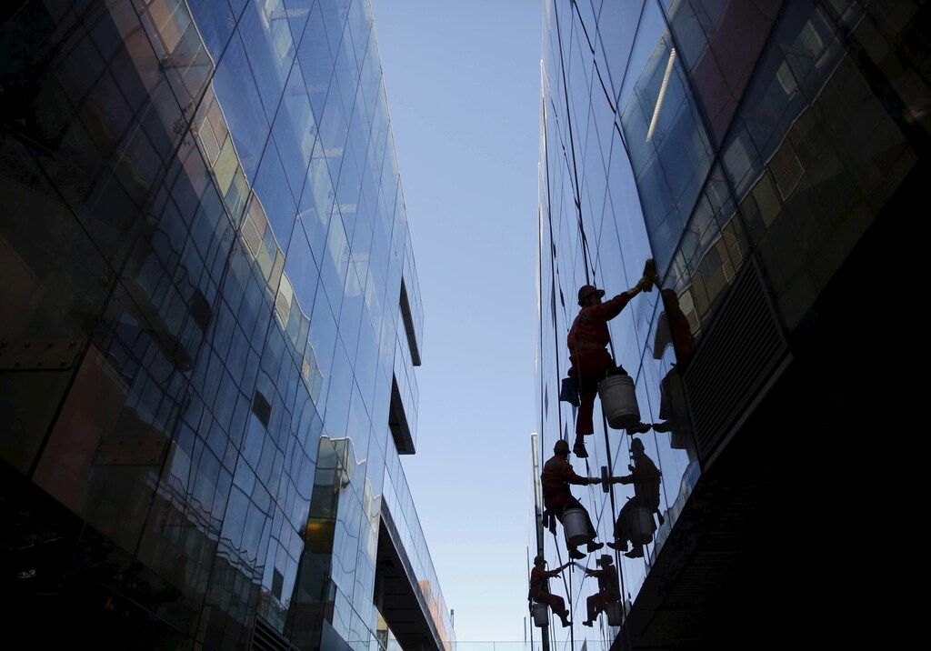 Workers clean windows of a shopping mall building in Beijing, October 30, 2015. China's Communist Party said on Thursday that it would target medium to high growth for the next five years, the official Xinhua news agency reported. REUTERS/Kim Kyung-Hoon TPX IMAGES OF THE DAY - GF20000038486