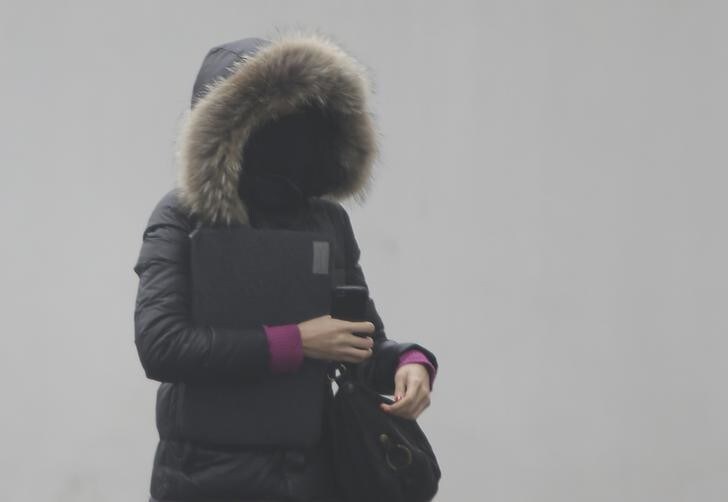 A woman wearing a mask walks on a heavy haze day during winter in Beijing January 29, 2013. Beijing's air pollution returns to 'hazardous' levels, two weeks after record readings of small particles in the air sparked a public outcry. REUTERS/Jason Lee (CHINA - Tags: ENVIRONMENT SOCIETY TPX IMAGES OF THE DAY)