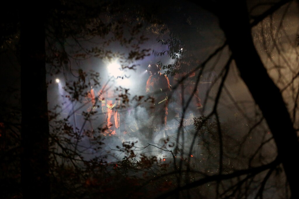 An inmate hand crew mops up hot spots along Wright creek during the Kincade fire in Healdsburg, California, U.S. October 28, 2019. REUTERS/Stephen Lam - RC1F55174190