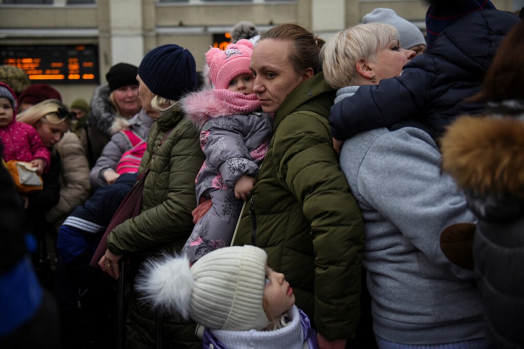 People displaced by the war in Ukraine wait for transportation away from a conflict zone.