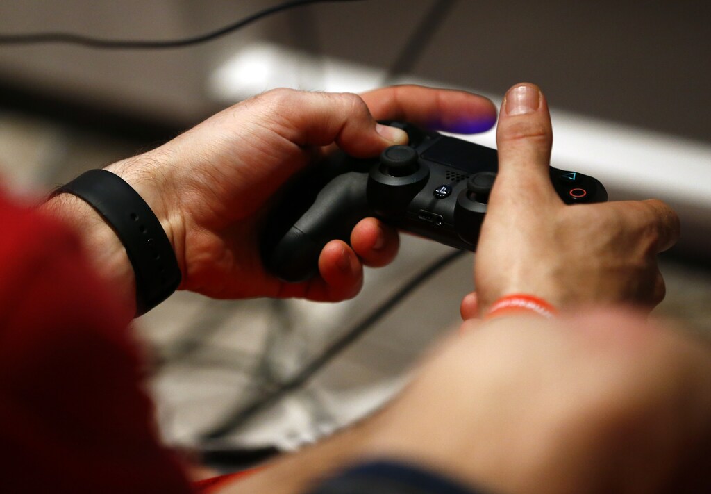 A man uses a Sony PlayStation controller during the Gamescom 2015 fair in Cologne, Germany August 6, 2015. The Gamescom convention, Europe's largest video games trade fair, runs from August 5 to August 9. REUTERS/Kai Pfaffenbach - RTX1NAIK