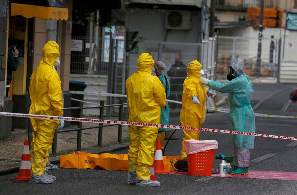 Medical staff members take off their protective suits after evacuating 170 asylum seekers from a hostel as the spread of the coronavirus disease (COVID-19) continues, in Lisbon, Portugal April 19, 2020. REUTERS/Rafael Marchante - RC2P7G9UUMJ4