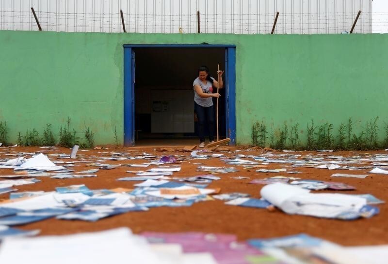 A woman sweeps the floor at a polling station during the presidential election, in the Ceilandia neighbourhood in Brasilia, Brazil October 7, 2018.