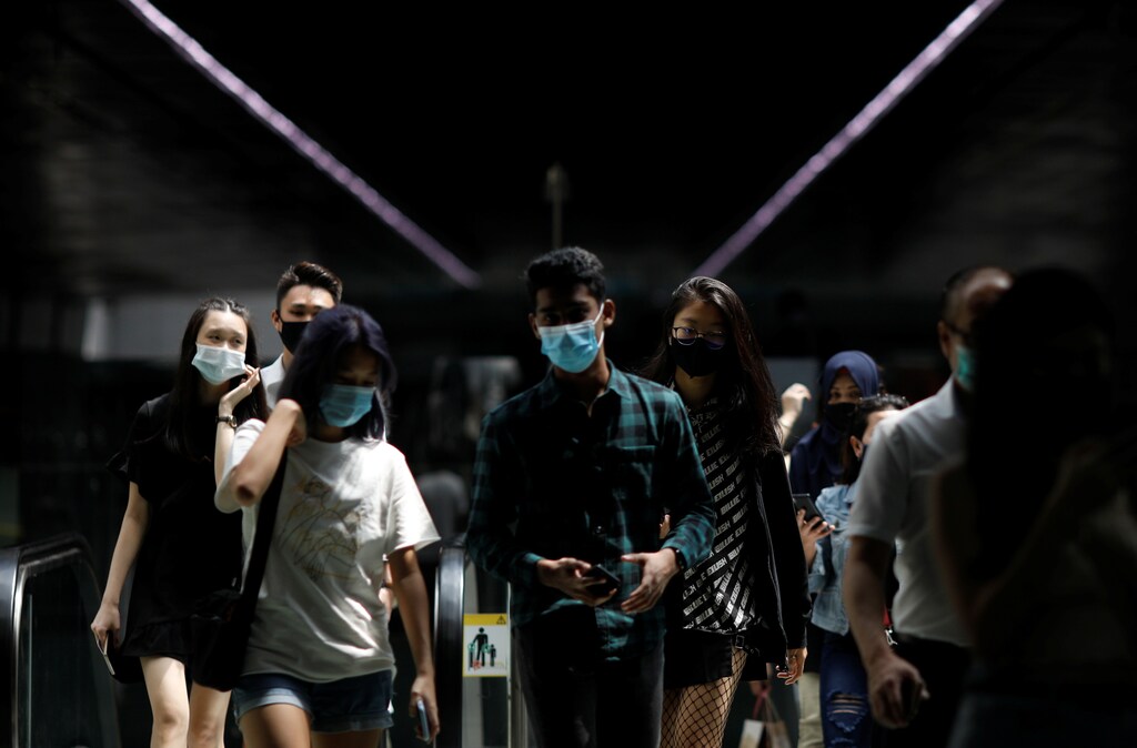 People wearing face masks leave a train station in Singapore December 8, 2020. REUTERS/Edgar Su - RC2WIK94ELKO