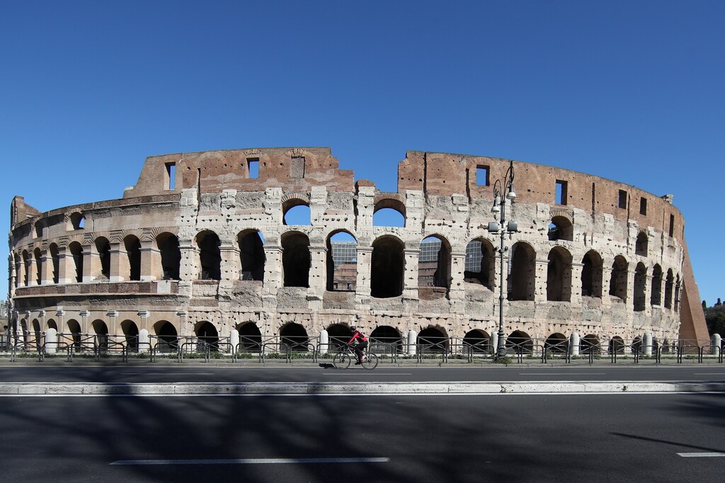 A person rides a bike in front of the Colosseum as Rome becomes a 'red zone', going into lockdown, as the country struggles to reduce the coronavirus disease (COVID-19) infections, in Rome, Italy, March 15, 2021. REUTERS/Yara Nardi - RC2MBM9LJI0U