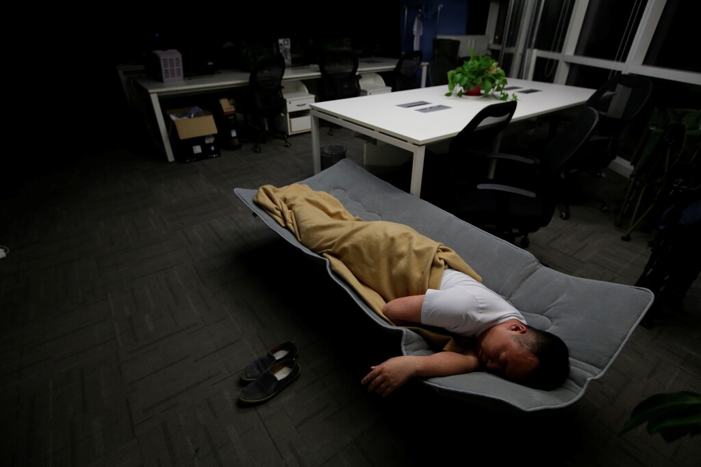 Ma Zhenguo, a system engineer at RenRen Credit Management Co., sleeps on a camp bed at the office after finishing work early morning, in Beijing, China, April 27, 2016. Office workers sleeping on the job is a common sight in China, where a surplus of cheap labour can lead to downtime at work. But in China's technology sector, where business is growing faster than many start-up firms can hire new staff, workers burn the midnight oil to meet deadlines and compete with their rivals. Some companies provide sleeping areas and beds for workers to rest during late nights. REUTERS/Jason Lee SEARCH "JASON SLEEP" FOR THIS STORY. SEARCH "THE WIDER IMAGE" FOR ALL STORIES TPX IMAGES OF THE DAY - S1BETDIDEDAA