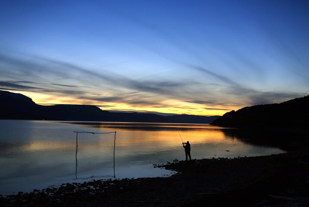 A man casts his fishing line in Bals-Fiord, north of the Arctic Circle, near the village of Mestervik in northern Norway September 30, 2014. REUTERS/Yannis Behrakis (NORWAY - Tags: ENVIRONMENT TRAVEL) - GM1EAA108Y301
