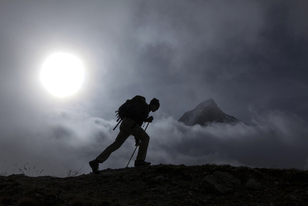 A hiker walks past the Matterhorn mountain at sunrise in the Swiss Alps near Zermatt September 11, 2013.