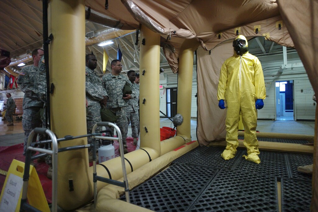 A soldier goes through the decontamination process with U.S. Army soldiers from the 101st Airborne Division (Air Assault), who are earmarked for the fight against Ebola, take part in training before their deployment to West Africa, at Fort Campbell, Kentucky October 9, 2014. The U.S. military is ramping up its response to the Ebola outbreak in West Africa, where it has already killed more than 3,400 people in Liberia, Sierra Leone and Guinea. REUTERS/Harrison McClary (UNITED STATES - Tags: HEALTH MILITARY DISASTER TPX IMAGES OF THE DAY) - GM1EAAA0LWG01