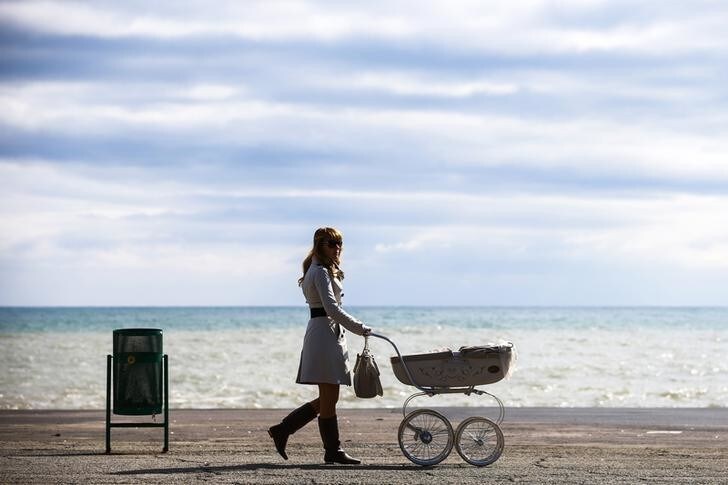 A woman pushes a pram along the embankment in the Black Sea resort town of Alushta March 11, 2014. Ukraine's Crimean peninsular evokes in many Russians and citizens of the former Soviet Union memories of summer holidays in the resorts and sanatoriums along its subtropical Black Sea coast. Crimea is also the place from where Christianity spread throughout what was then called Kievan Rus', a federation of Slavic tribes that later became Russia. REUTERS/Thomas Peter (UKRAINE - Tags: POLITICS SOCIETY TRAVEL TPX IMAGES OF THE DAY)