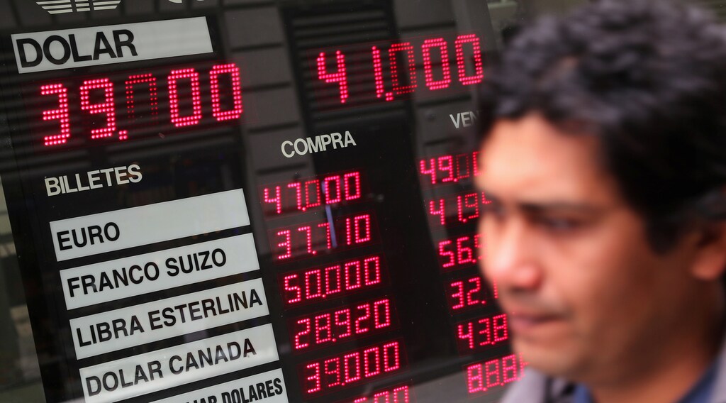 A man walks past a currency exchange board in Buenos Aires' financial district, Argentina October 1, 2018. REUTERS/Marcos Brindicci