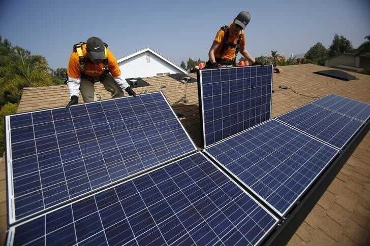 Vivint Solar technicians Eduardo Aguilar (L) and Ian Boshard install solar panels on the roof of a house in Mission Viejo, California October 25, 2013. REUTERS/Mario Anzuoni (UNITED STATES - Tags: ENERGY)