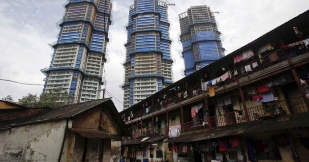High-rise residential towers under construction are pictured behind an old residential building in central Mumbai September 9, 2011. REUTERS/Vivek Prakash (INDIA - Tags: CITYSPACE BUSINESS)