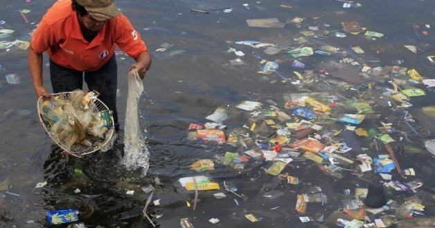 A government sanitary worker collects and segregate garbage, mostly assorted plastic products polluting in Manila bay July 3, 2014.