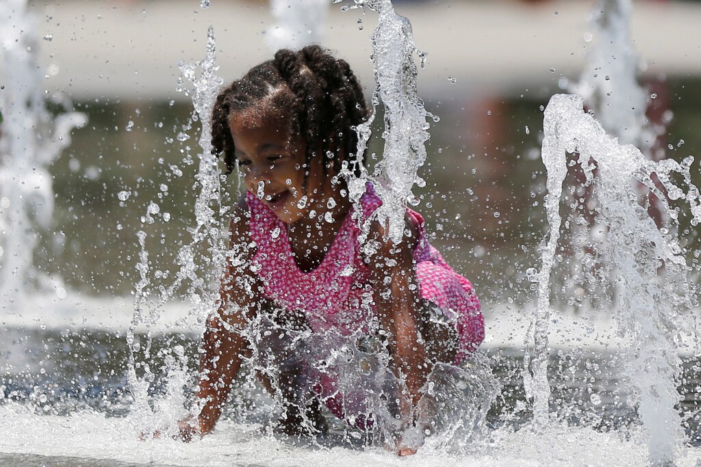 A girl keeps cool in a park fountain during hot weather in Los Angeles, California, U.S. July 6, 2017. REUTERS/Lucy Nicholson - RTX3AE02