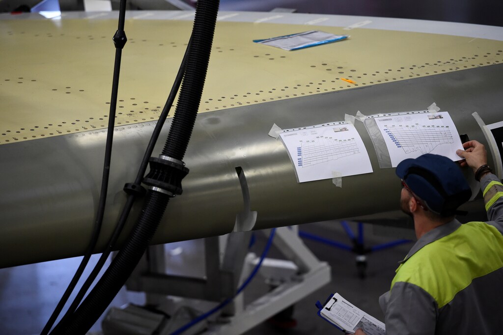A man looks at paperwork on C Series aeroplane wing in the Bombardier factory in Belfast, Northern Ireland September 26, 2017. REUTERS/Clodagh Kilcoyne - RC1474376BB0
