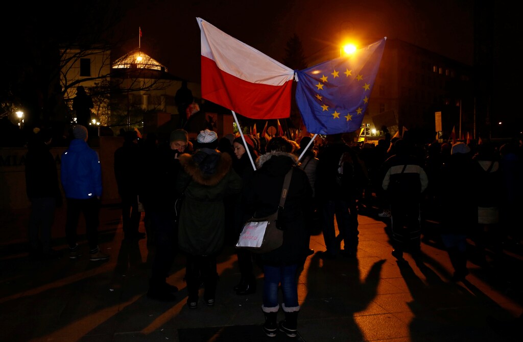 Demonstrators hold Polish and EU flags during a protest outside the Parliament building in Warsaw, Poland December 17, 2016. REUTERS/Kacper Pempel - RTX2VG8M
