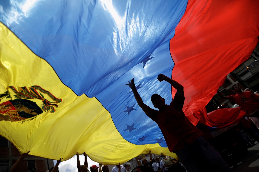 Pro-government supporters holding a Venezuela's flag attend a rally against U.S President Donald Trump in Caracas, Venezuela August 14, 2017. REUTERS/Ueslei Marcelino - RC1C4C85F820