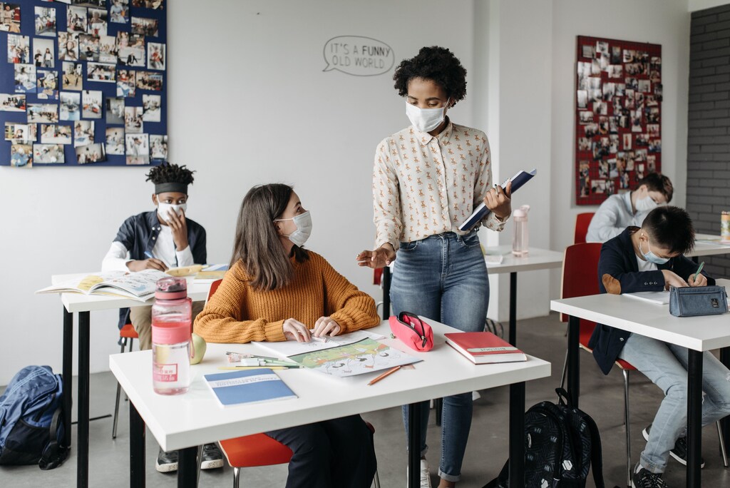 A teacher and students with face masks on.