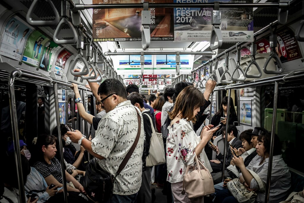People on phone in busy metro train: Nonprofits quietly underpin global cyber resilience