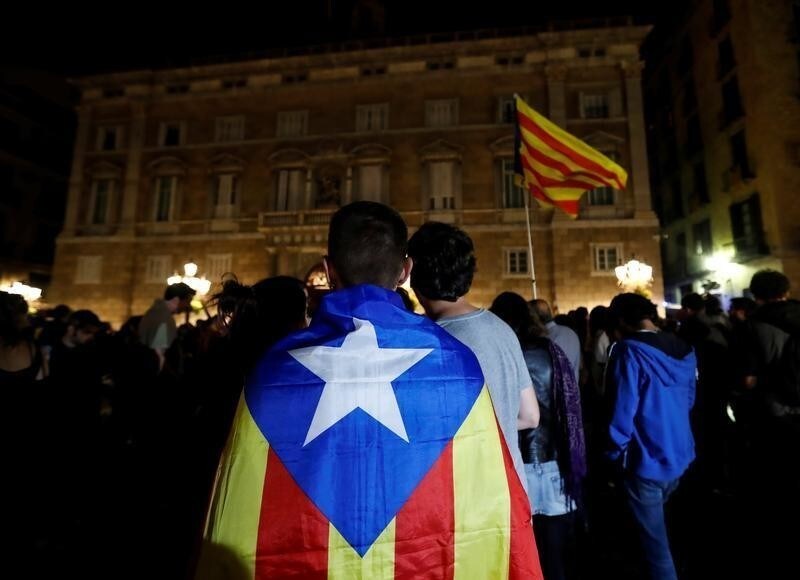 A man wears an Estelada, Catalan separatist flag, as protesters gathered outside the regional government headquarters after Spain's High Court jailed the leaders of two of the largest separatist organizations, the Catalan National Assembly's Jordi Sanchez and Omnium's Jordi Cuixart, in Barcelona, Spain, October 16, 2017. REUTERS/Gonzalo Fuentes - RC1160469E00