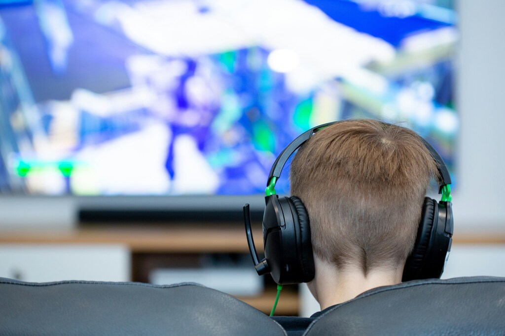 A child is seen wearing a headset and gaming.