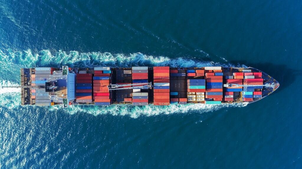 Aerial view of a container ship in a blog about the urgent need for action to decarbonize shipping.