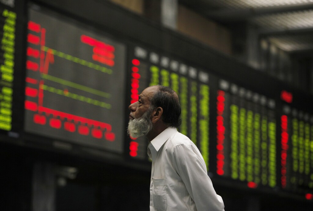 A broker monitors an electronic board displaying stock prices during a trading session at Karachi Stock Exchange October 16, 2014. Access to credit allows both individuals and businesses to pursue long term financial goals.