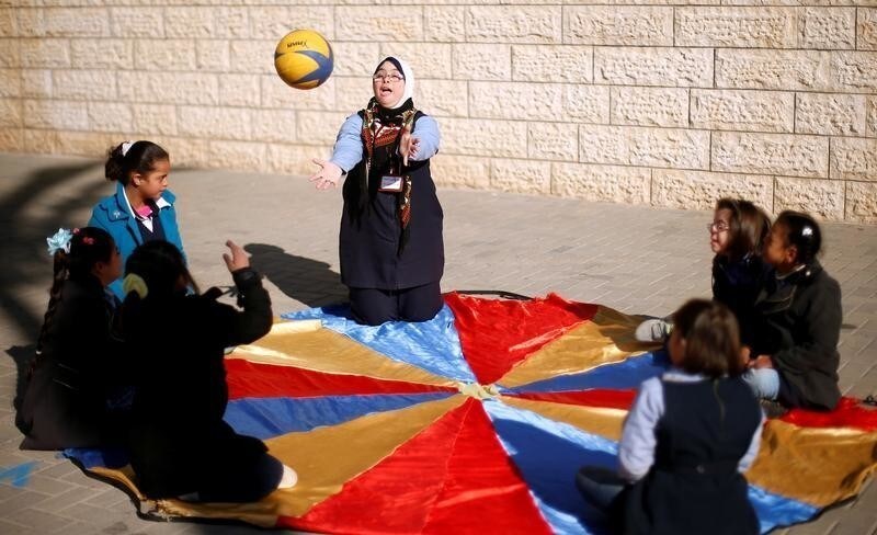Hiba Al-Sharfa, a twenty seven-year-old Palestinian teacher aide with Down Syndrome, plays with students with Down Syndrome in a school at the Right to Live Society, in Gaza City December 21, 2016.