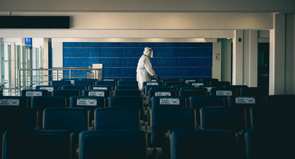 Someone in a protective suit disinfecting empty seats in China.