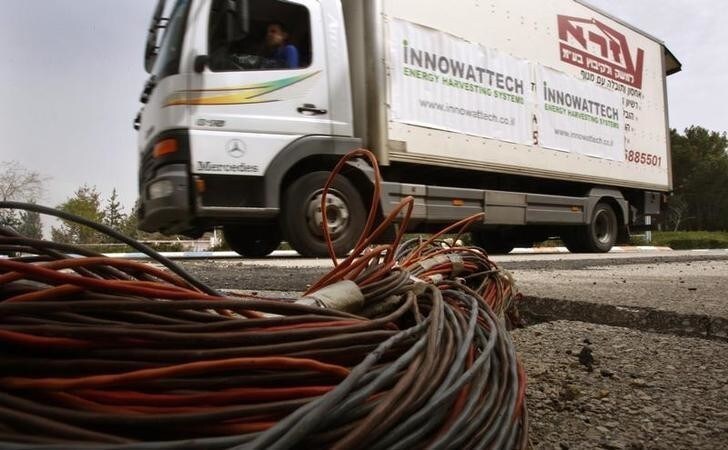 A truck drives over generators buried under the road during a simulation of piezoelectric production at the Technion Institute of Technology in the northern Israeli city of Haifa March 8, 2009. Innowattech, an energy company affiliated with Israel's Technion Institute of Technology, said special generators placed under roads, railways and runways can harvest enough energy from passing vehicles to mass-produce electricity. Picture taken March 8, 2009. REUTERS/Gil Cohen Magen (ISRAEL SCI TECH ENERGY BUSINESS)