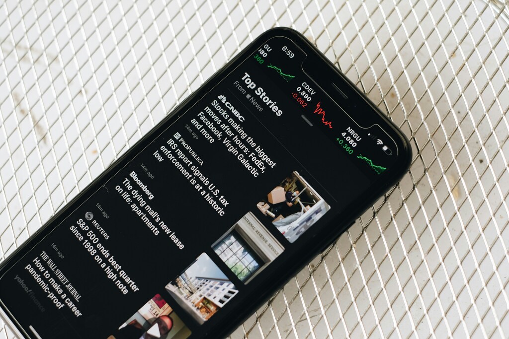 A mobile phone with news alerts displayed on the screen.