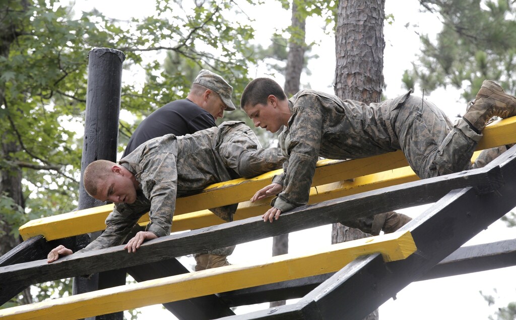 Captain Kristen Griest (R) participates in the Darby Queen obstacle course as part of the training at the Ranger Course on Ft. Benning Georgia, June 28, 2015.