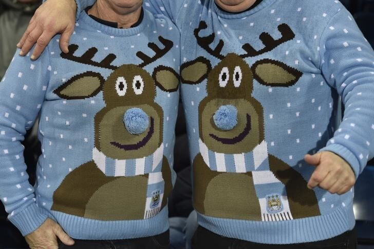 Fans wear Christmas jumpers during the English Premier League soccer match between Manchester City and West Bromwich Albion at The Hawthorns in West Bromwich, central England December 26, 2014. REUTERS/Toby Melville (BRITAIN - Tags: SOCCER SPORT) FOR EDITORIAL USE ONLY. NOT FOR SALE FOR MARKETING OR ADVERTISING CAMPAIGNS. EDITORIAL USE ONLY. NO USE WITH UNAUTHORIZED AUDIO, VIDEO, DATA, FIXTURE LISTS, CLUB/LEAGUE LOGOS OR 'LIVE' SERVICES. ONLINE IN-MATCH USE LIMITED TO 45 IMAGES, NO VIDEO EMULATION. NO USE IN BETTING, GAMES OR SINGLE CLUB/LEAGUE/PLAYER PUBLICATIONS.