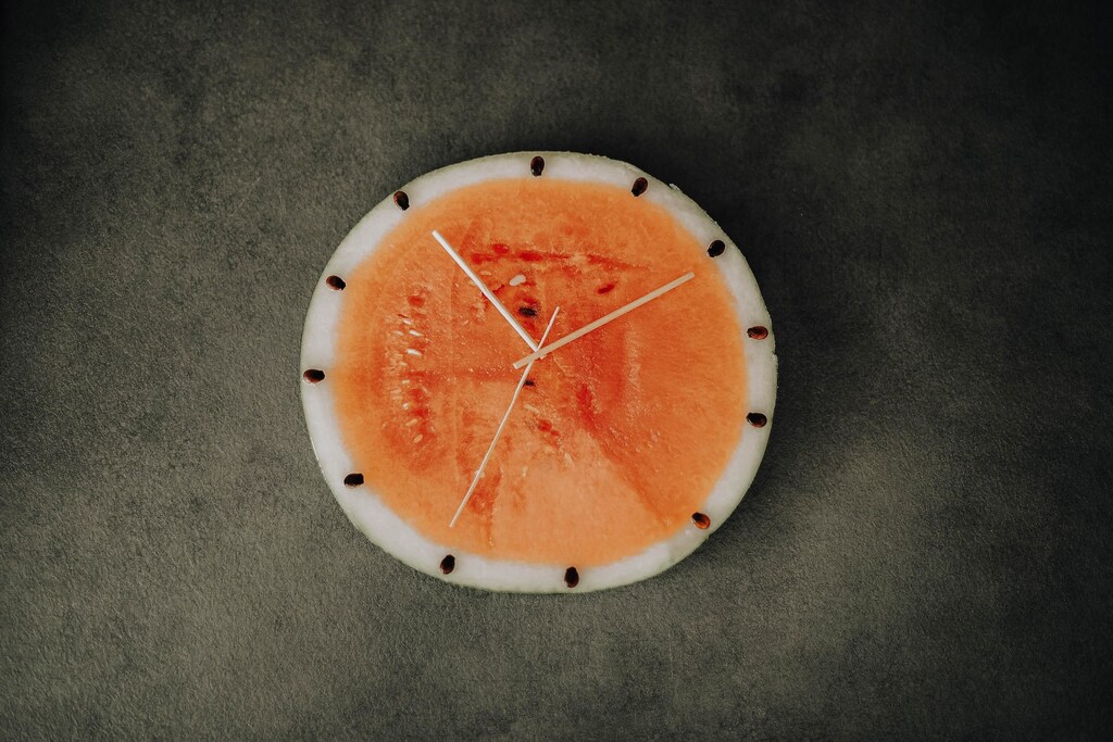 A melon cut and decorated to look like a clock.