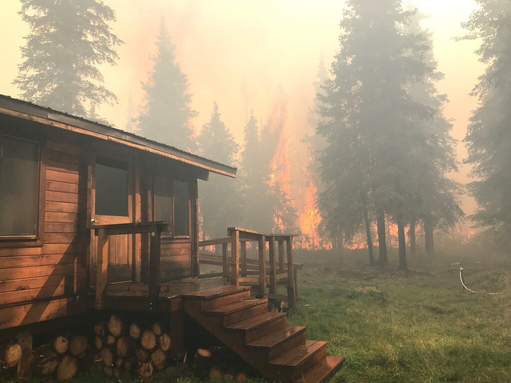 Firefighters from the Chugach National Forest work to protect the Romig Cabin on Juneau Lake from the Swan Lake Fire near Cooper Landing, Alaska, U.S. in this August 28, 2019 handout photo. Chugach National Forest/Handout via REUTERS ATTENTION EDITORS - THIS IMAGE WAS PROVIDED BY A THIRD PARTY. - RC17D6156610
