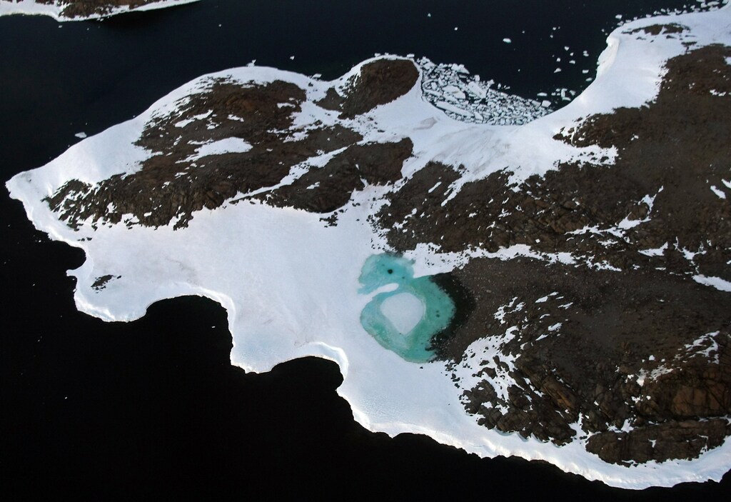 A turquoise lake (C) forms from melting snow near Cape Folger on the Budd Coast in the Australian Antarctic Territory, January 11, 2008. Australia's CSIRO's atmospheric research unit has found the world is warming faster than predicted by the United Nations' top climate change body, with harmful emissions exceeding worst-case estimates. Picture taken January 11, 2008. REUTERS/Torsten Blackwood/Pool (ANTARCTICA) - GM1DXGHASHAA