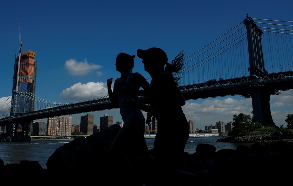 Two women jog near Manhattan Bridge in Brooklyn, New York