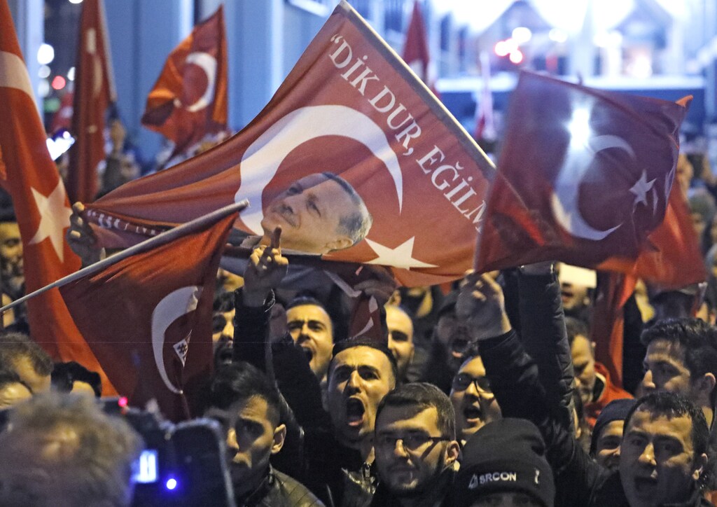 Demonstrators with banners of Turkish President Recep Tayyip Erdogan gather outsidethe Turkish consulate to welcome the Turkish Family Minister Fatma Betul Sayan Kaya, who decided to travel to Rotterdam by land after Turkish Foreign Minister Mevlut Cavusoglu's flight was barred from landing by the Dutch government, in Rotterdam, Netherlands March 11, 2017. REUTERS/Yves Herman - RTX30MBF