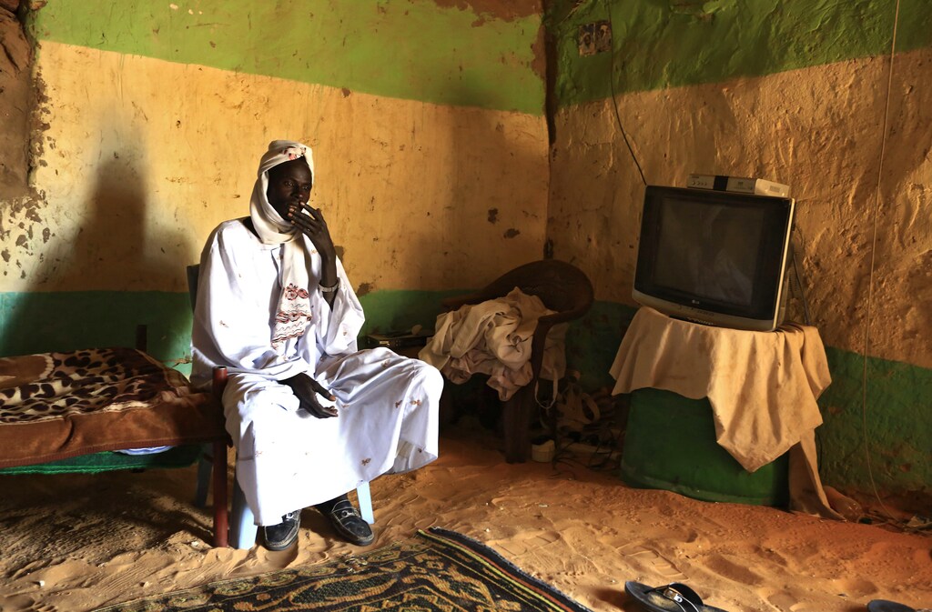 A Sudanese from the Bedouin ethnic group sits inside his house near the collection site for Trona, a natural form of sodium carbonate minerals, from Oasis Natron in Malha, a town in Sudan's North Darfur, February 13, 2015. Trona crystallizes into a glass-like hard rocky substance as result of chemical reactions when natural forms of sodium carbonate minerals settle on water, and is used in the manufacturing of glass, chemicals, and in the production of textiles. Picture taken February 13, 2015. REUTERS/Mohamed Nureldin Abdallah (SUDAN - Tags: SOCIETY SCIENCE TECHNOLOGY BUSINESS INDUSTRIAL TEXTILE TPX IMAGES OF THE DAY) - RTR4Q1AQ