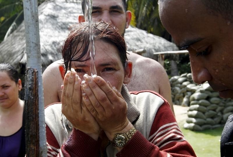 A Cuban migrant drinks water as she arrives safe in to town after she cross the border from Colombia through the jungle in to La Miel border with Colombia in the province of Guna Yala November 26, 2015. Scores of Cubans have come to shore at a remote outpost in Panama near the Colombian border as they seek overland passage towards the United States fearing a recent detente between Washington and Havana could end their preferential treatment. According to local Authorities in La Miel some 100 to 150 Cubans cross the Panama border from Colombia coming from Ecuador.