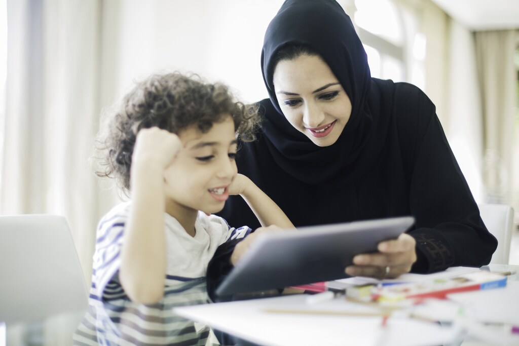 Middle eastern mother helping her child with homework. non-profit