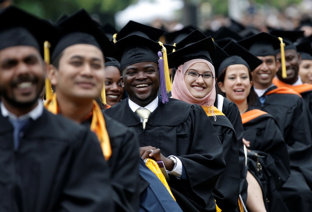 Graduating students of the City College of New York sit together in their caps and gowns as they listen to U.S. first lady Michelle Obama's address during the College's commencement ceremony in the Harlem section of Manhattan, New York, U.S., June 3, 2016. REUTERS/Mike Segar - RTX2FKNP